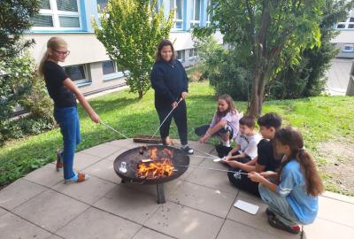 Opékání vuřtů a míčové hry v atriu školy